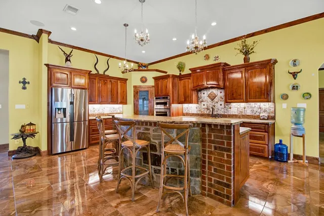 a kitchen with stainless steel appliances kitchen island granite countertop a refrigerator and microwave