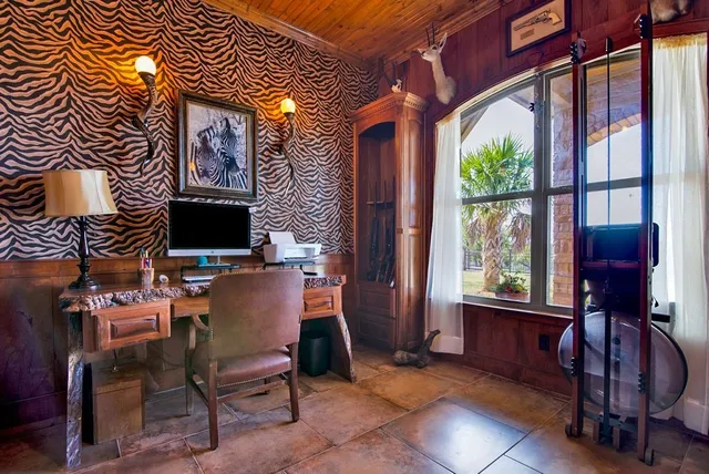 a view of a workspace with furniture and a window