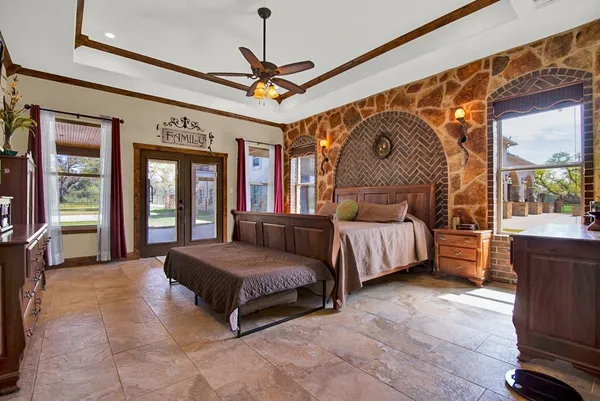 a spacious bedroom with a bed and a chandelier