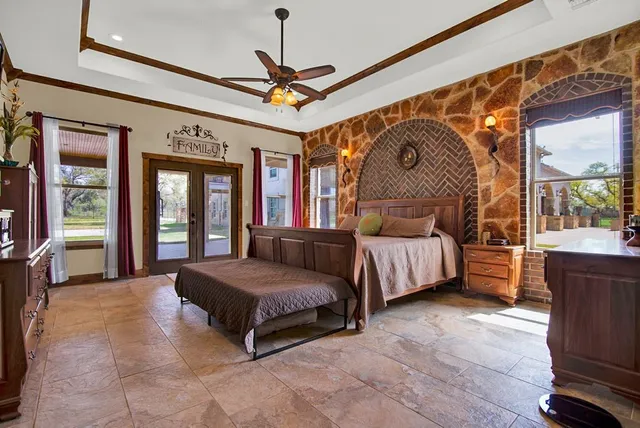 a spacious bedroom with a bed and a chandelier