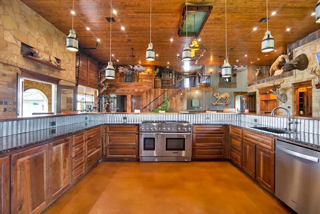 a kitchen with stainless steel appliances granite countertop a stove and cabinets