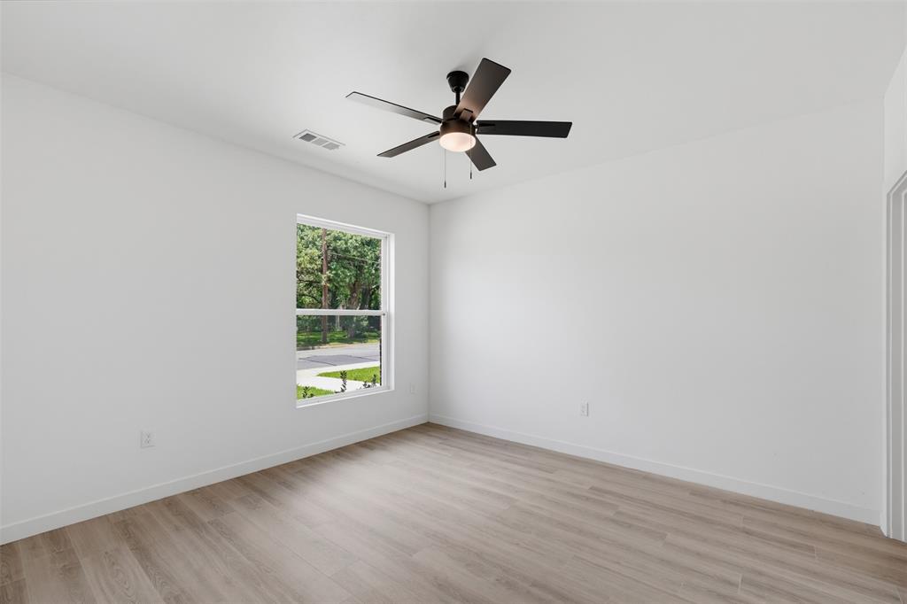 512 South O Connor Road Irving, TX 75060 - Photo 5 of 21 Room featuring wood-finish flooring, white walls, a single window, a ceiling fan with light fixture, and white baseboards