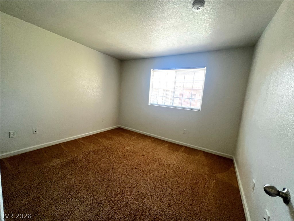 4730 East Craig Road, Unit 2104 Las Vegas, NV 89115 - Photo 9 of 20 A well-lit bedroom offering a warm, inviting atmosphere with plush carpeting.