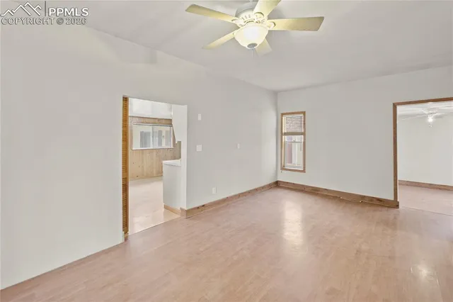 an empty room with fan and windows