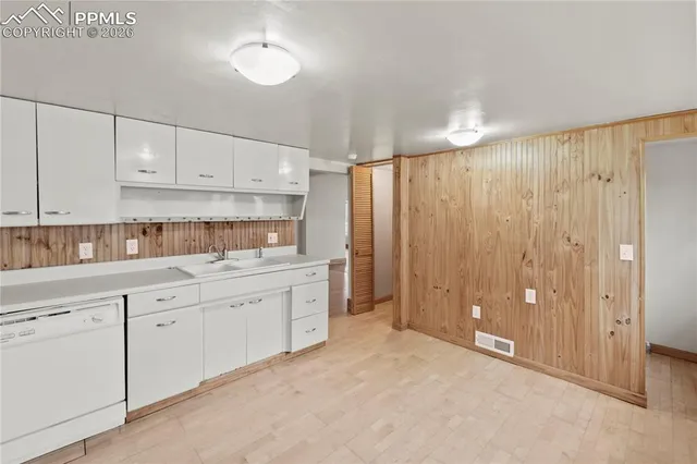 a kitchen with granite countertop a sink cabinets and stainless steel appliances