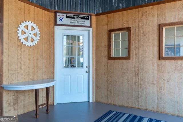 a view of a hallway with wooden floor and a bathroom
