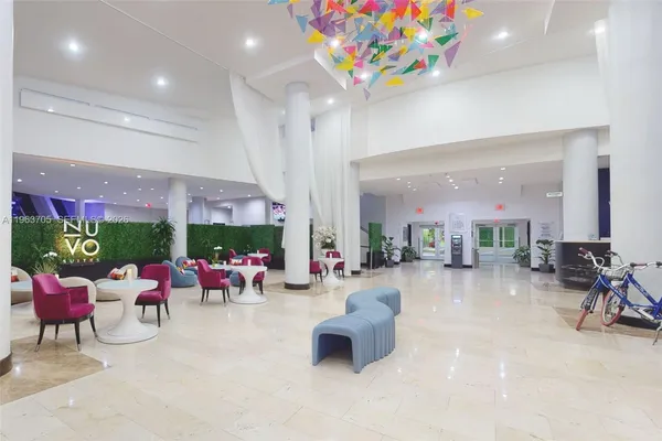 a living room with furniture a chandelier and a floor to ceiling window