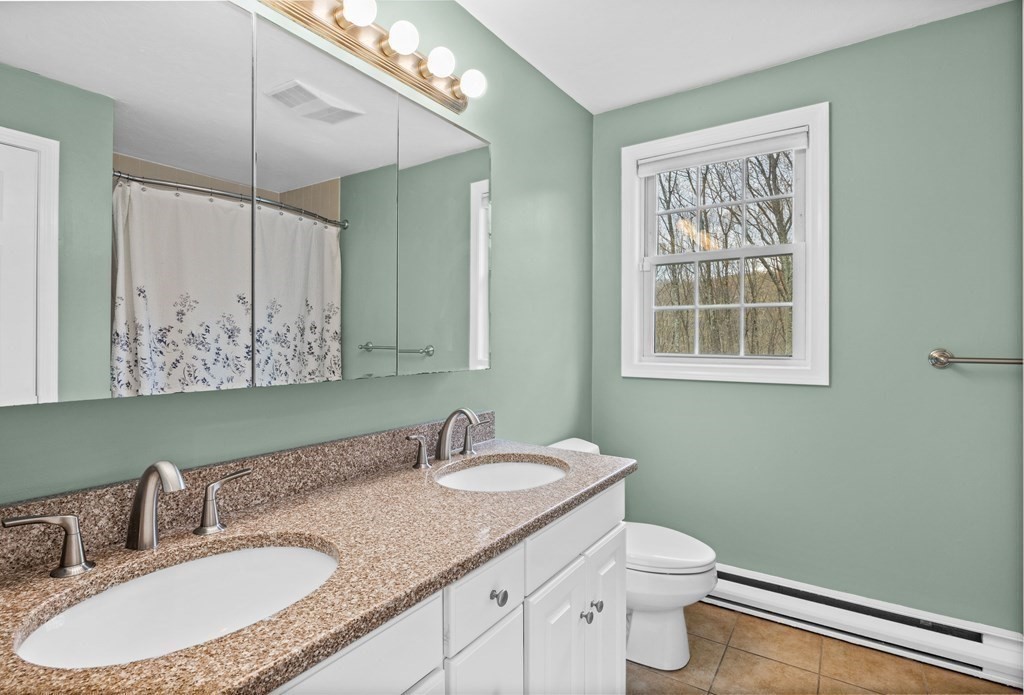 71 Old Worcester Road Charlton, MA 01507 - Photo 12 of 24 a bathroom with a granite countertop sink mirror vanity and toilet