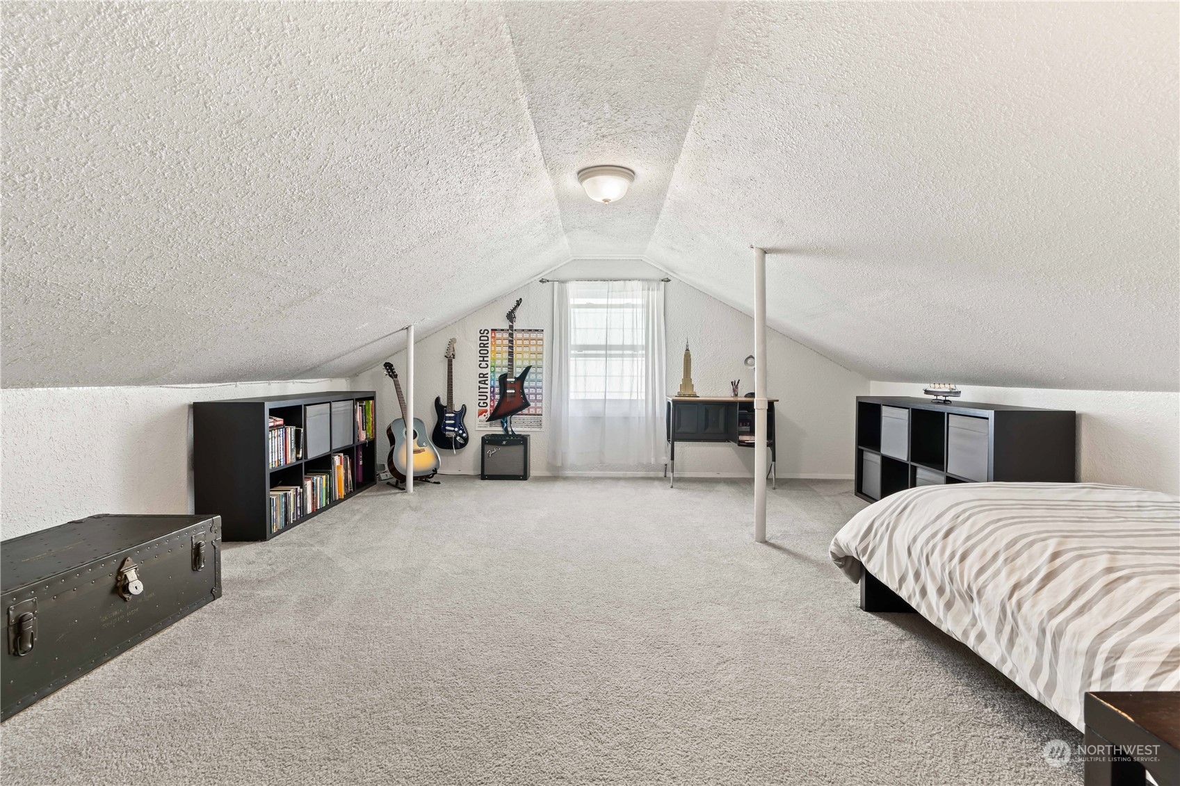 1616 Maple Street Sumner, WA 98390 - Photo 20 of 40 a spacious bedroom with a bed a mirror and lamp