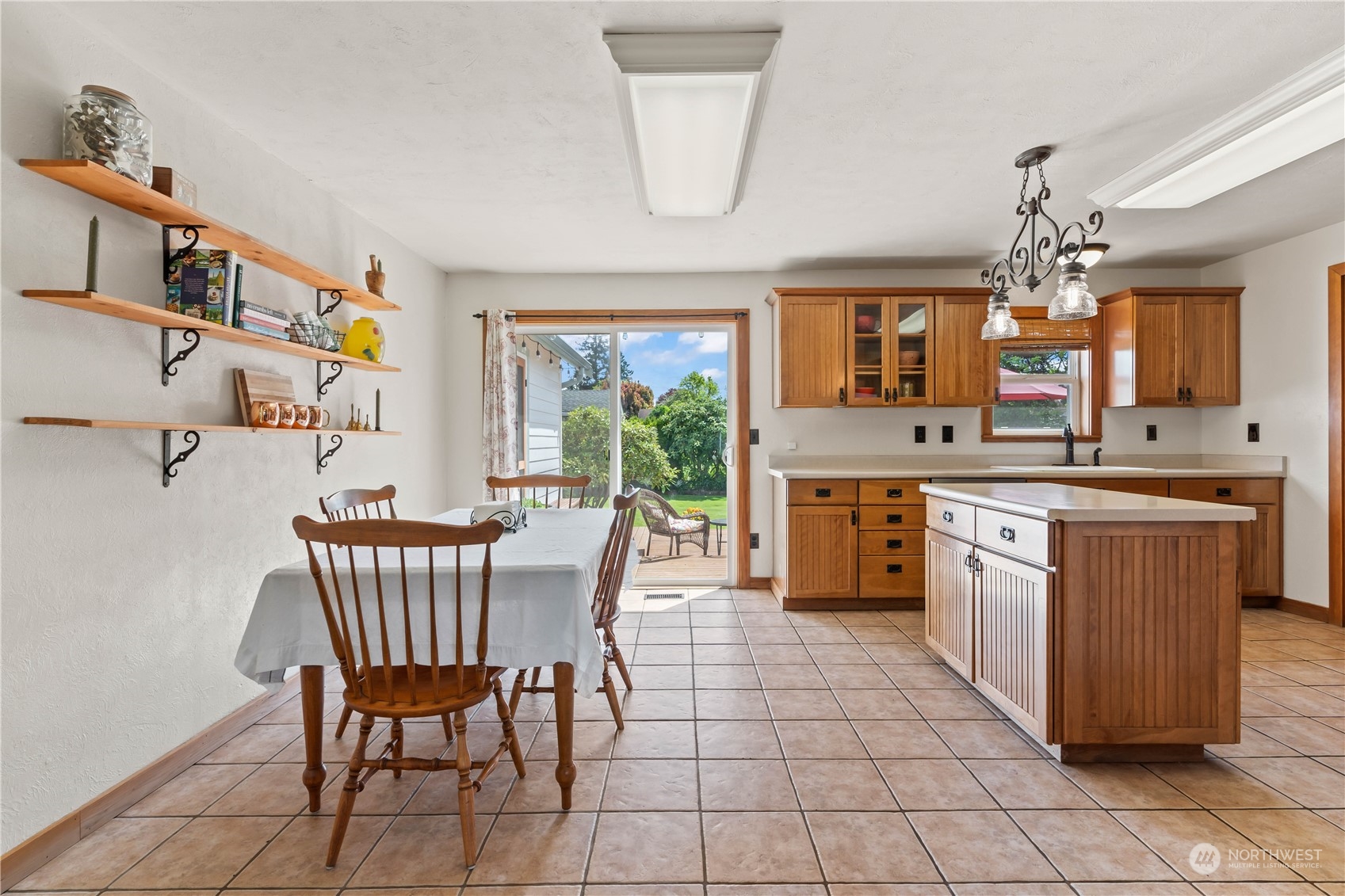 1616 Maple Street Sumner, WA 98390 - Photo 7 of 40 a kitchen with stainless steel appliances granite countertop a stove a sink dishwasher a dining table and chairs with wooden floor