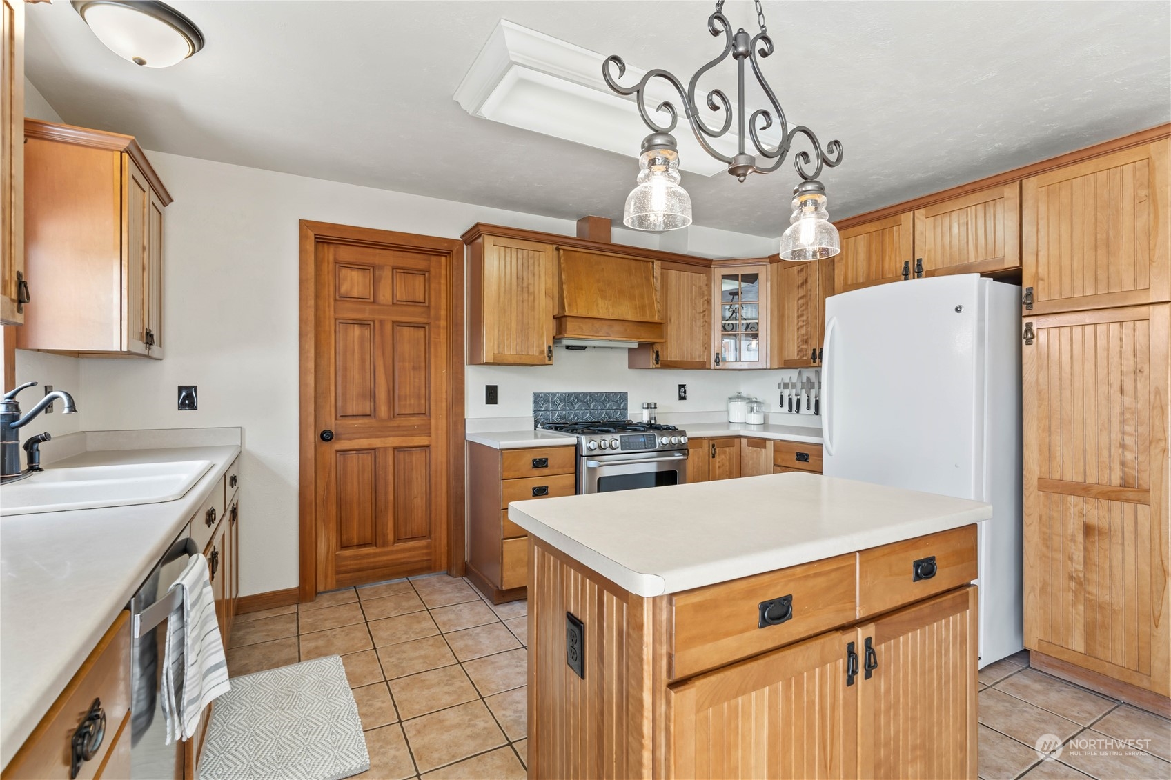 1616 Maple Street Sumner, WA 98390 - Photo 8 of 40 a kitchen with a refrigerator a sink and cabinets