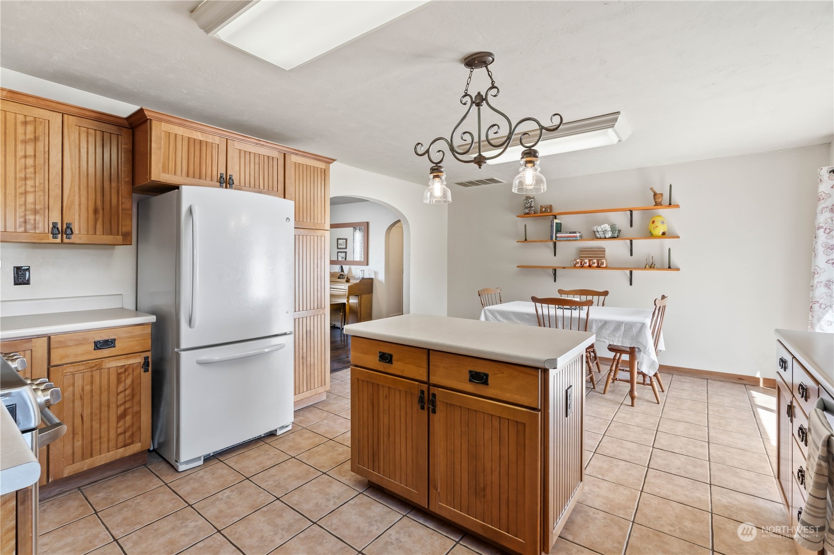 1616 Maple Street Sumner, WA 98390 - Photo 10 of 40 a kitchen with a refrigerator a microwave oven a sink and a dining table