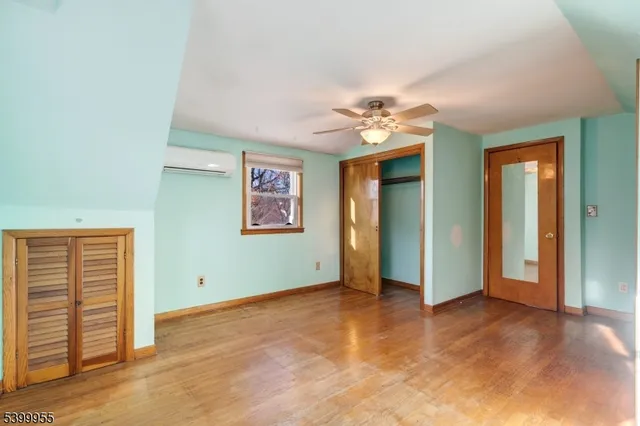 an empty room with closet and a ceiling fan