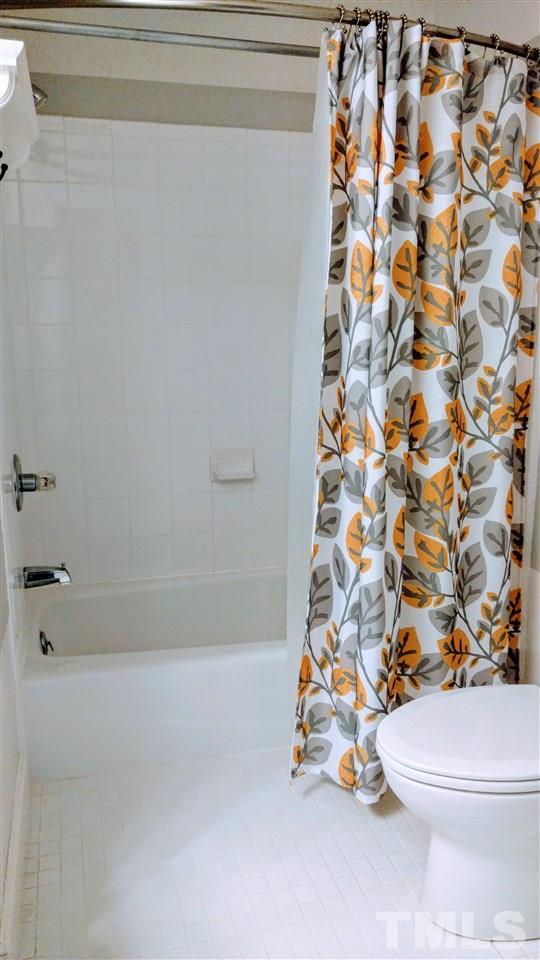5517 Mapleridge Road Raleigh, NC 27609 - Photo 14 of 17 a white toilet sitting next to a shower curtain