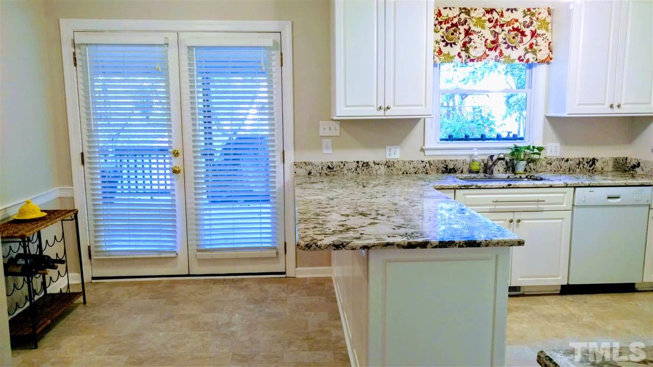 5517 Mapleridge Road Raleigh, NC 27609 - Photo 5 of 17 a kitchen with granite countertop white cabinets and white appliances