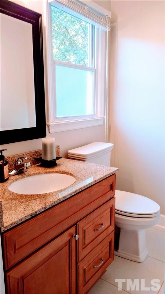 5517 Mapleridge Road Raleigh, NC 27609 - Photo 8 of 17 a bathroom with a granite countertop toilet sink and mirror