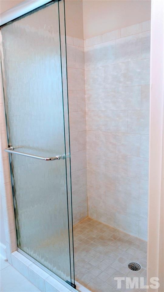 5517 Mapleridge Road Raleigh, NC 27609 - Photo 9 of 17 a bathroom with a glass shower door