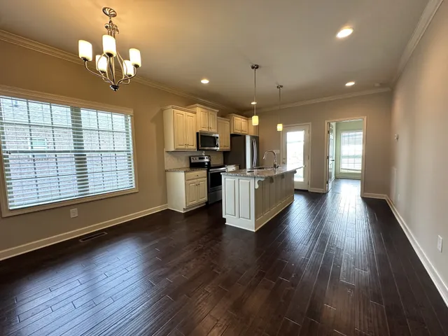 a view of a kitchen with granite countertop stainless steel appliances and wooden floor