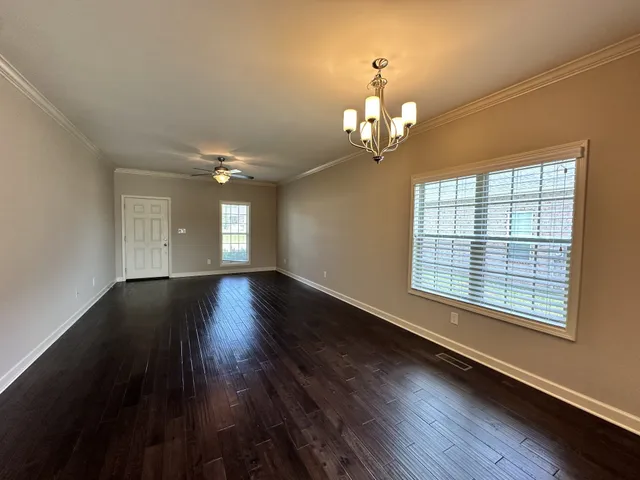 a view of empty room with wooden floor and window