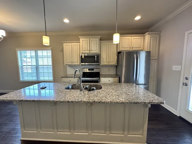 a kitchen with refrigerator and chairs