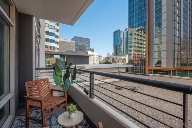 a view of a balcony with chairs and a potted plant