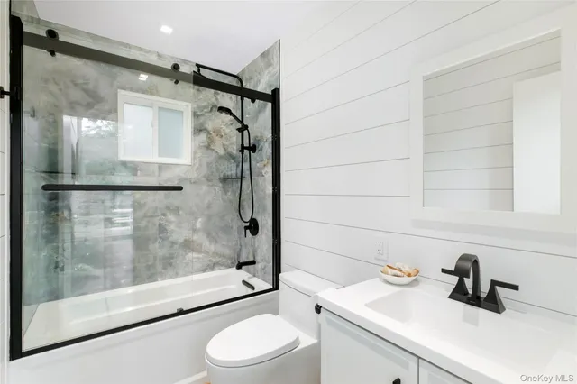 a bathroom with a sink mirror toilet and shower