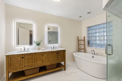 a bathroom with a granite countertop sink a toilet a mirror and shower