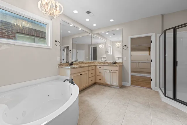 a bathroom with a tub a sink shower and a mirror