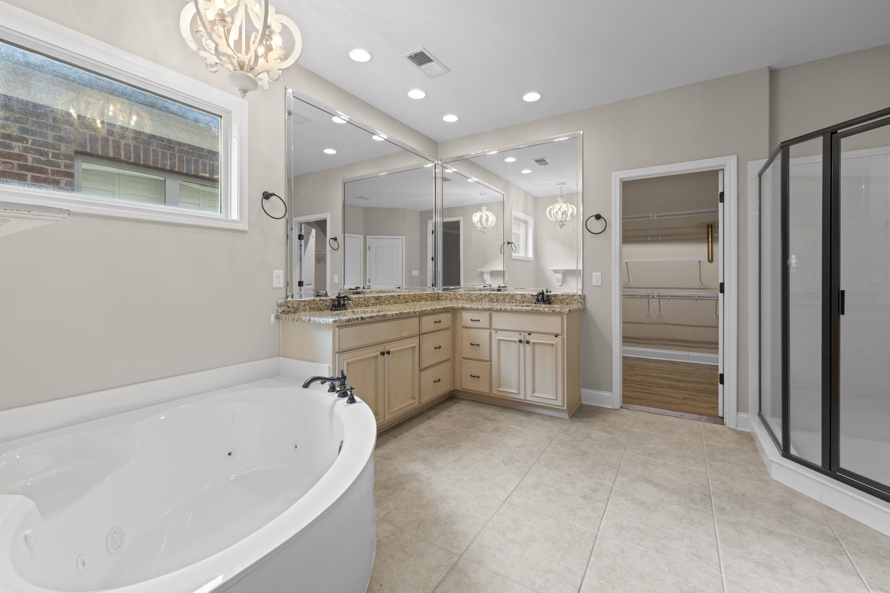 389 South Tarren Mill Circle Collierville, TN 38017 - Photo 19 of 32 a bathroom with a tub a sink shower and a mirror