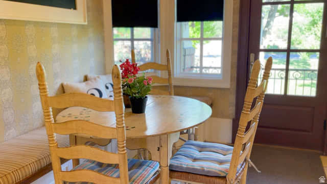 426 West Center Street Parowan, UT 84761 - Photo 40 of 107 Breakfast nook featuring built-in bench seating with striped cushions, patterned wallpaper, double-pane windows, and an exterior door with glass panels