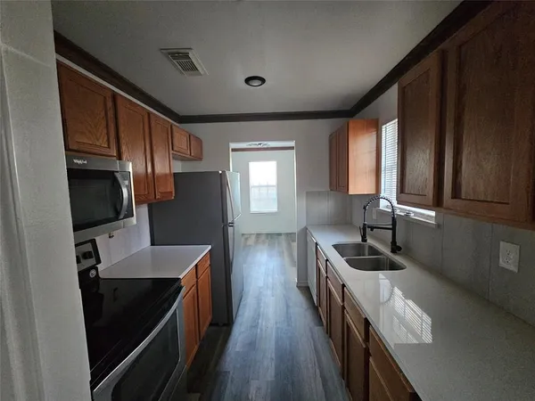 a kitchen with granite countertop a stove sink and cabinets