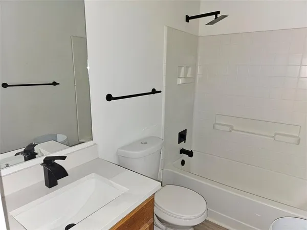 a white toilet sitting next to a bath tub
