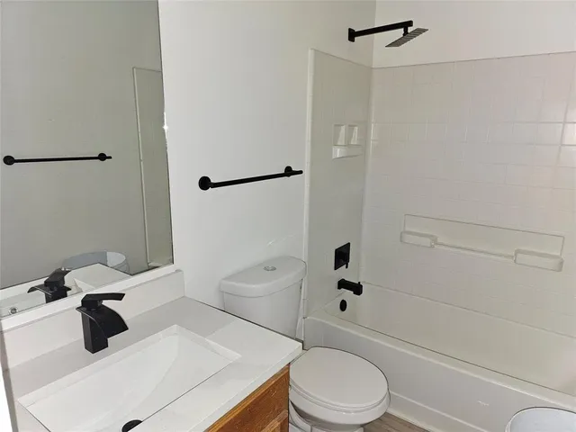 a white toilet sitting next to a bath tub