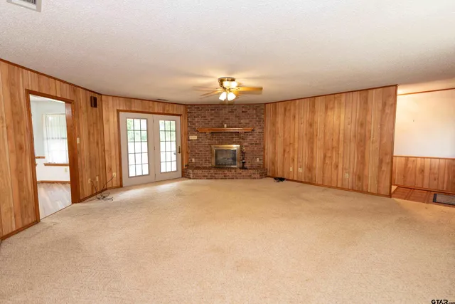an empty room with a fireplace and window