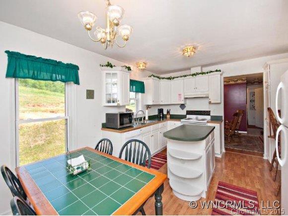 378 Yates Cove Road Waynesville, NC 28785 - Photo 5 of 17 a kitchen with a table chairs stove and refrigerator