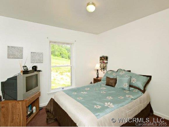 378 Yates Cove Road Waynesville, NC 28785 - Photo 10 of 17 a bed sitting in a bedroom next to a window