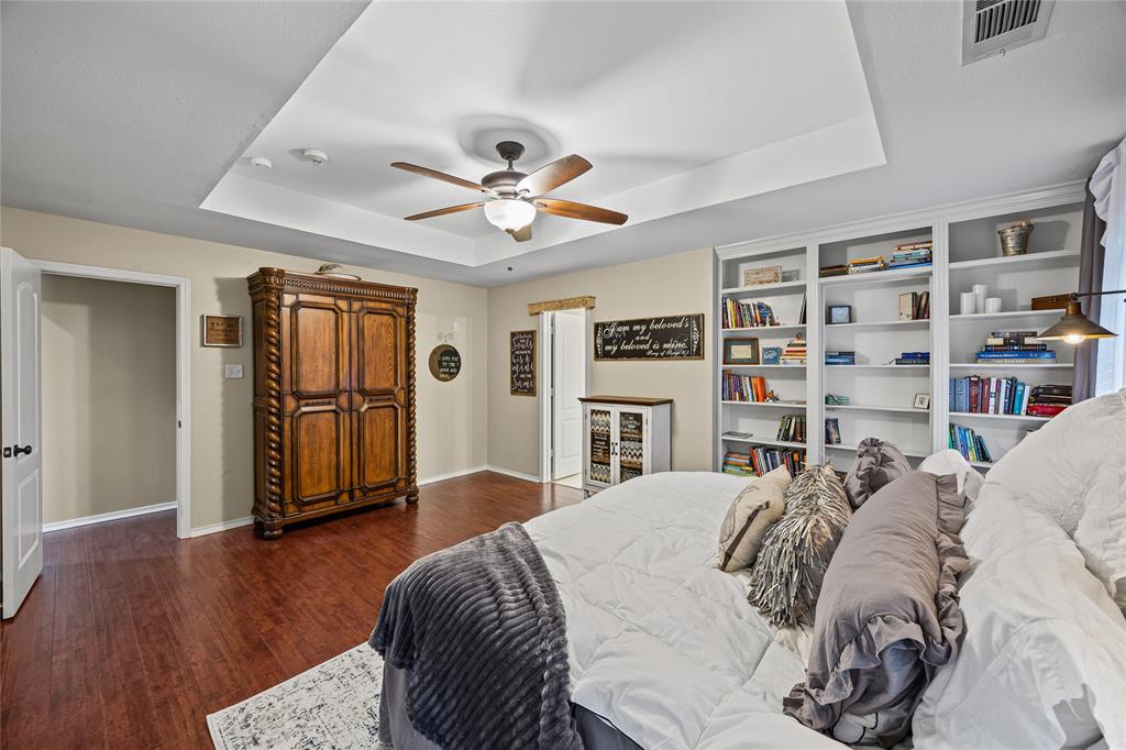 112 Springfield Lane Red Oak, TX 75165 - Photo 17 of 40 a bedroom with a large bed and a chandelier
