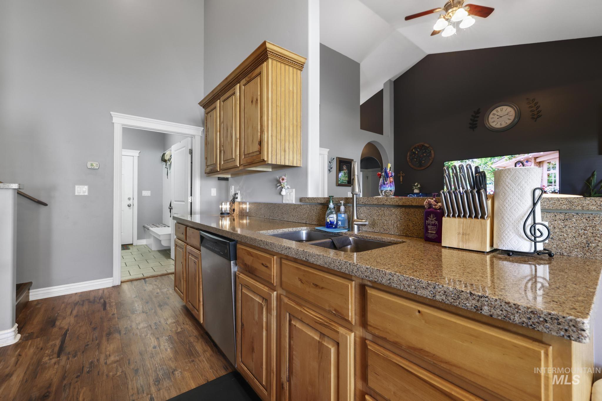 467 Wildrose Loop Twin Falls, ID 83301 - Photo 16 of 46 Kitchen featuring granite-style countertops, wood-finish flooring, stainless steel dishwasher, double basin sink, and wood cabinetry