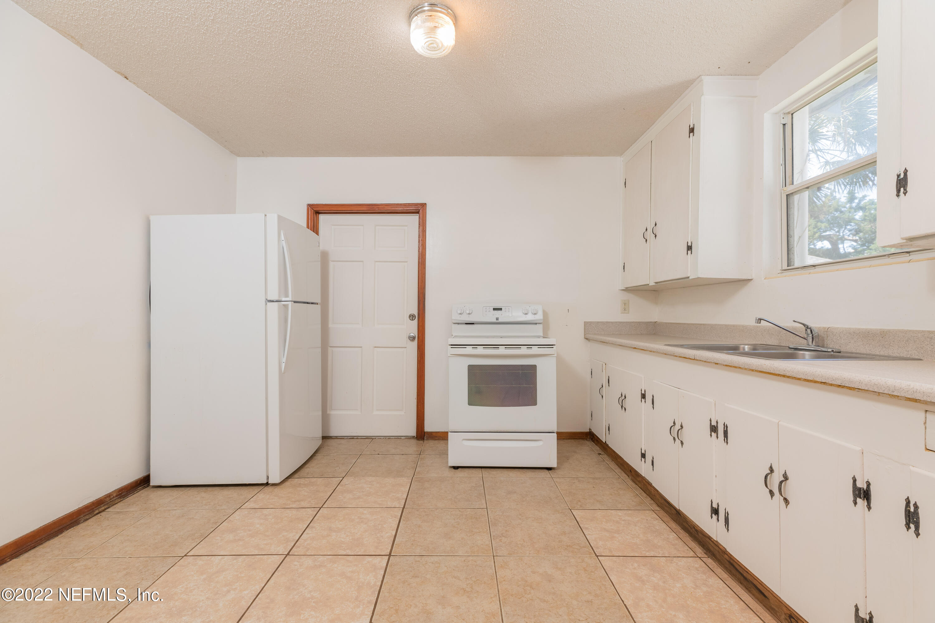 306 Ribault Street St. Augustine, FL 32080 - Photo 15 of 31 a kitchen with granite countertop white cabinets and white appliances
