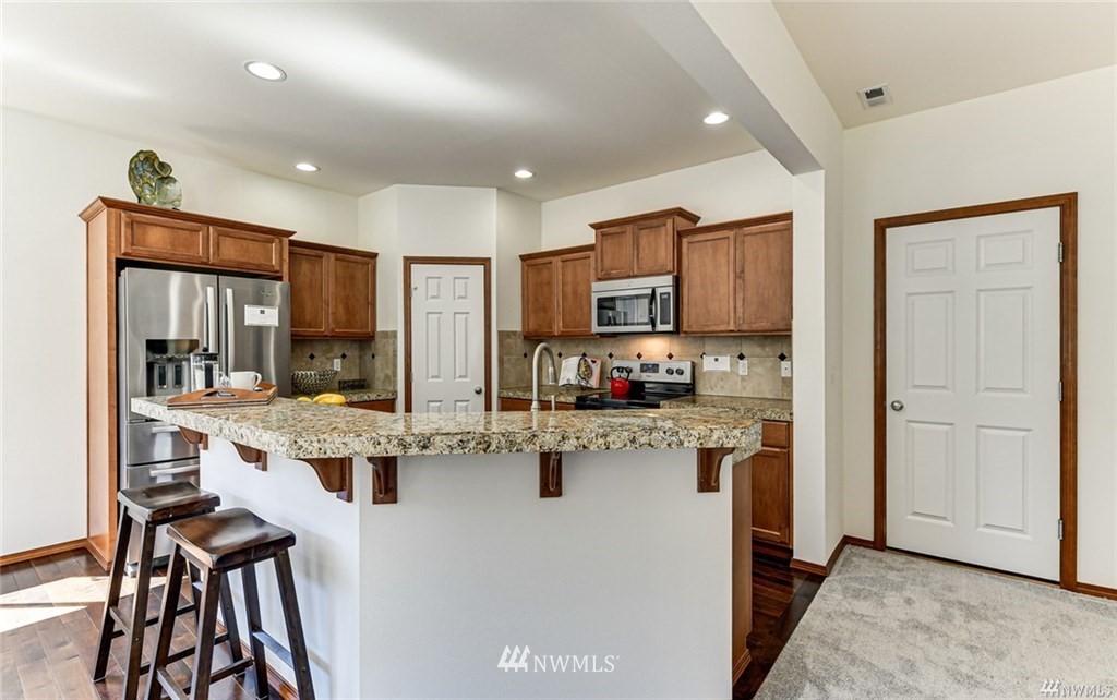 23007 42nd Drive Southeast Bothell, WA 98021 - Photo 6 of 29 a kitchen with white cabinets and refrigerator
