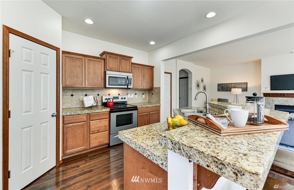 23007 42nd Drive Southeast Bothell, WA 98021 - Photo 7 of 29 a kitchen with stainless steel appliances granite countertop a sink stove refrigerator and cabinets