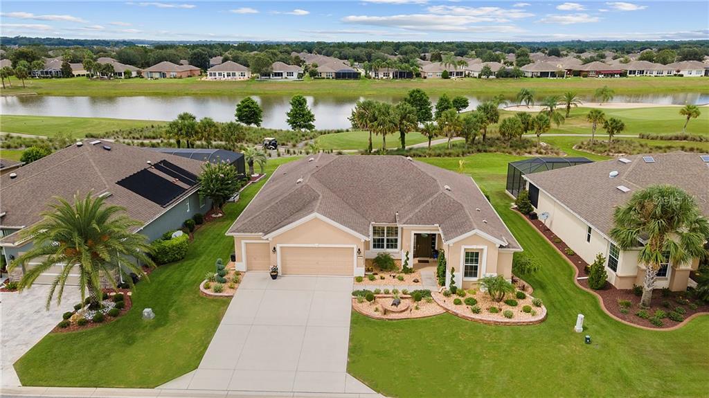 7497 Southwest 97th Terrace Road Ocala, FL 34481 - Photo 1 of 1 an aerial view of a house with garden space and lake view