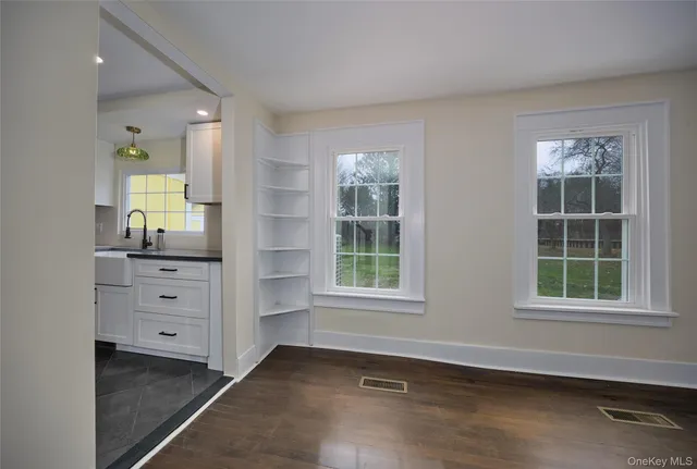 an empty room with windows and cabinet