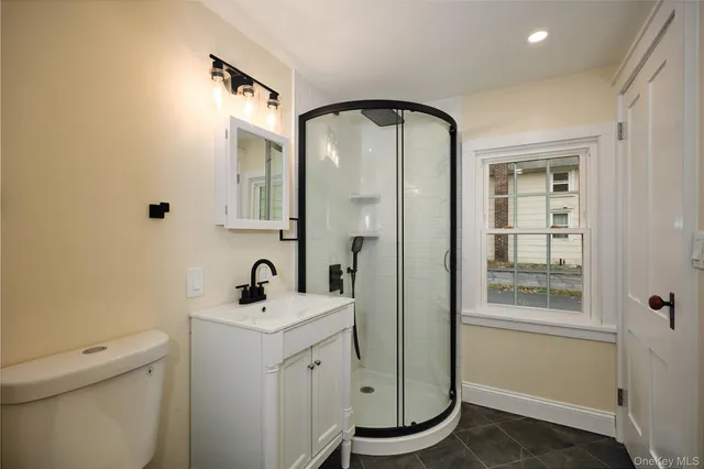 a bathroom with a toilet sink shower and mirror