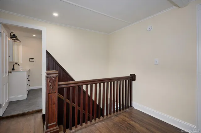 a view of a hallway with wooden floor and staircase
