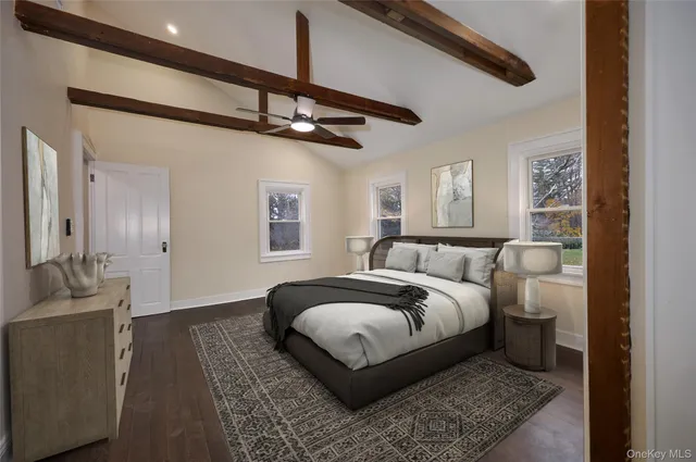 a spacious bedroom with a bed a chandelier and glass door