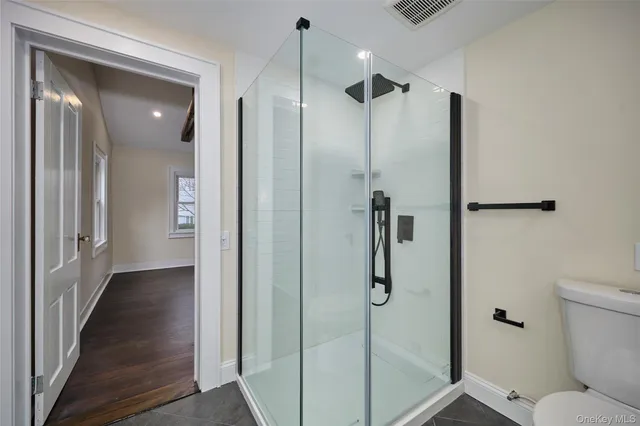 a bathroom with a shower and a glass door