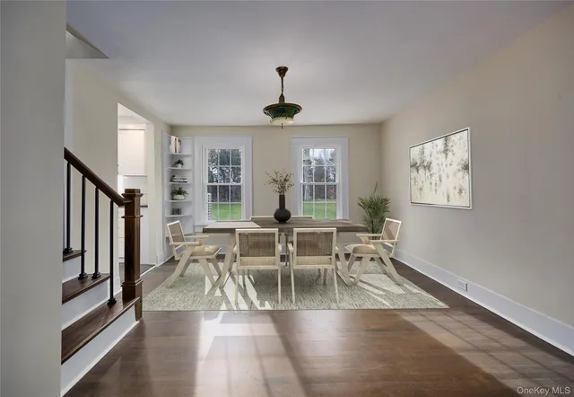 a dining room with wooden floor a chandelier a glass table and chairs