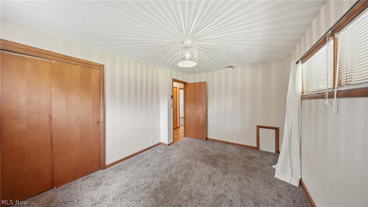 89 Dagg Road Parkersburg, WV 26101 - Photo 31 of 45 Room featuring neutral striped wallpaper, gray carpet, and natural wood trim