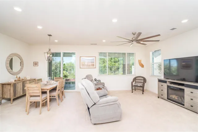a dining room with wooden floor a chandelier a wooden table and chairs